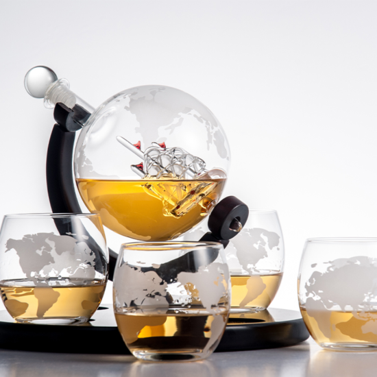 стъклен декантер глобус с гравирана карта на света и стъклен кораб вътре