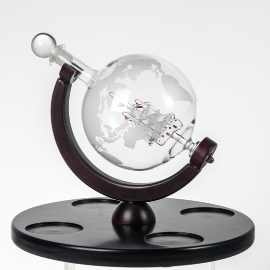 стъклен декантер глобус с гравирана карта на света и стъклен кораб вътре