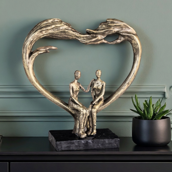 Бронзова статуетка на мъж и жена седящи в рамка сърце върху черна основа