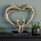Бронзова статуетка на мъж и жена седящи в рамка сърце върху черна основа