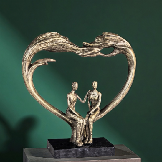 Бронзова статуетка на мъж и жена седящи в рамка сърце върху черна основа
