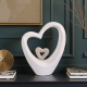 Бяла порцеланова статуетка във формата на голямо сърце с по-малко сърце в центъра