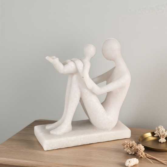 Бяла минималистична статуетка с ефект на камък, изобразяваща майка, която вдига детето си във въздуха