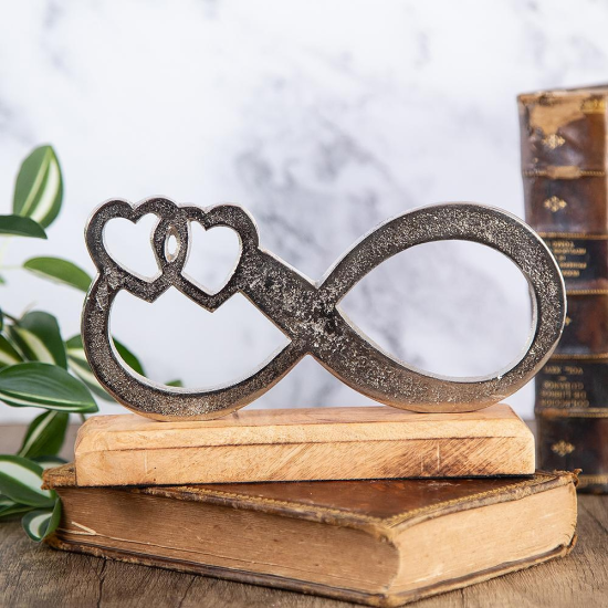 сребриста статуетка знак за безкрайност с две сърца на дървена основа