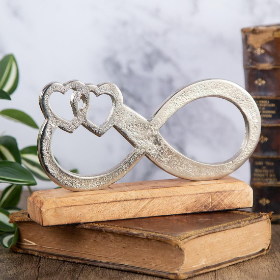 сребриста статуетка знак за безкрайност с две сърца на дървена основа