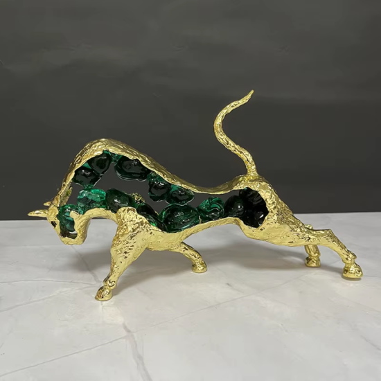 Луксозна статуетка на златен бик, изработена от метал със златно покритие, чийто контур е изпълнен с натрошени зелени кристали